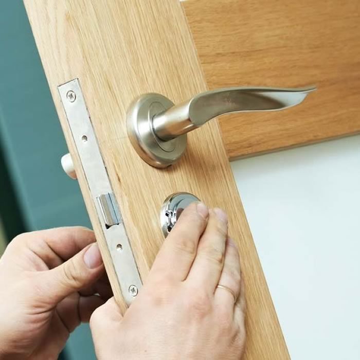 Locksmith repairing a door lock